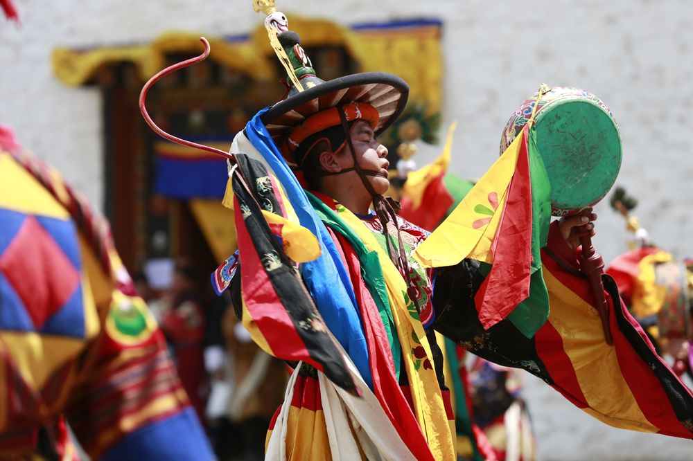 A masked dancer performing at a Bhutanese tshechu festival